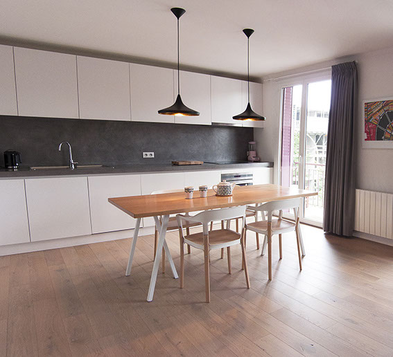 Salle à manger avec plateau de table en hêtre, 4 chaises Steelwood des frères Bouroullec. 2 lampes suspendues Beat Light Wilde de Tom Dixon.