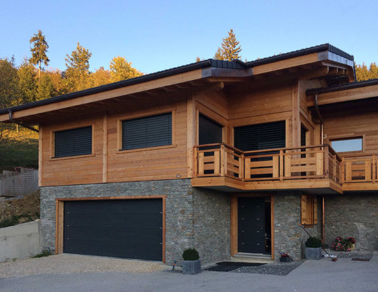 Vue du l'extension du chalet en fin de chantier. Réalisation des bardages bois et parement de pierres naturelles sur le soubassement.