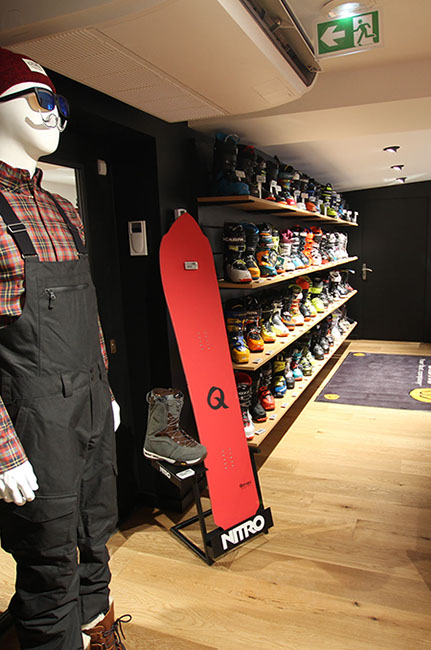 Linéaire de chaussures et cabines d'essayage au fond.