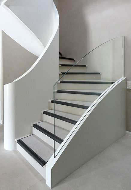 L'escalier en structure bois, avec garde-corps en verre et marche en pierre.