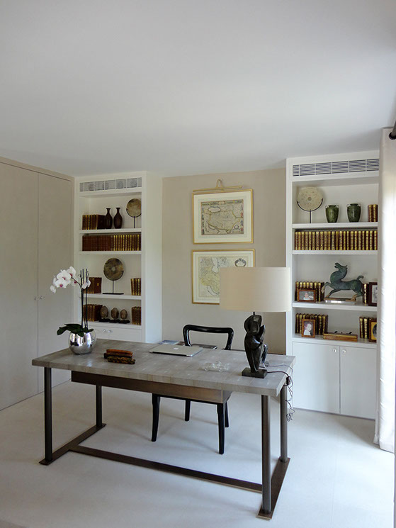 Bureau avec rangements et bilbiothèques ouvert sur le petit salon. Le bureau a un pietement métalique ton bronze et plateau en galuchat.