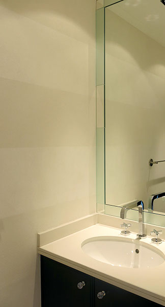 Salle de bains. Meuble lavabo avec tablette en pierre et grand miroir.
